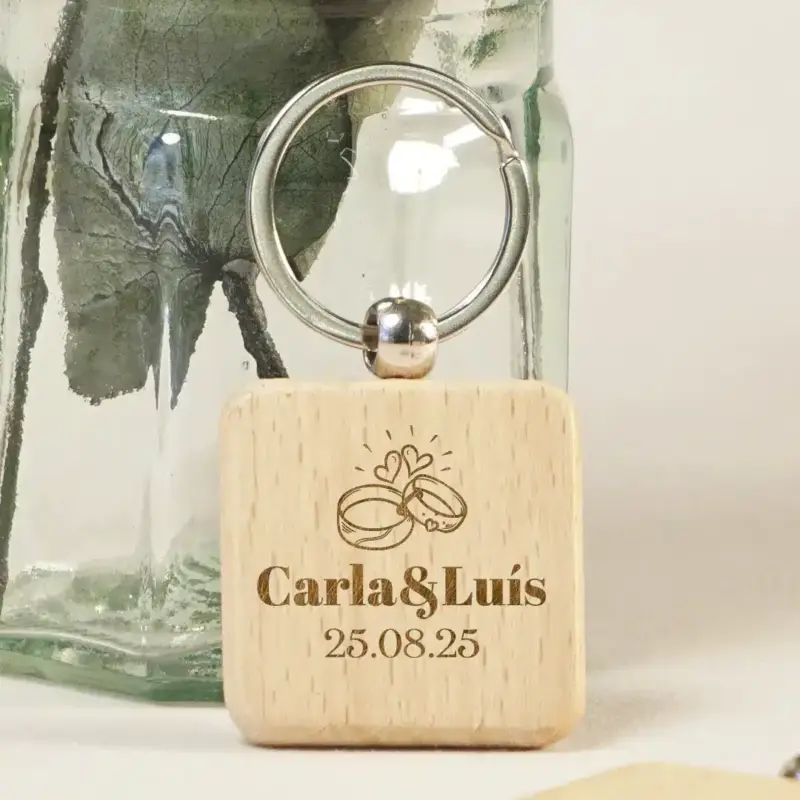 Detalle del grabado personalizado con nombres y fecha en llavero de madera redondo.