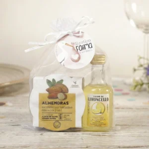 Pack de regalo gourmet con tarro de almendras tostadas La Chinata y botella de licor miniatura en bolsa de organza.