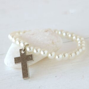 Pulsera de perlas con abalorio de cruz religiosa.